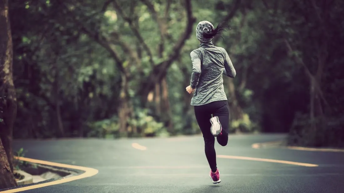 Kobieta biegnąca po asfalcie