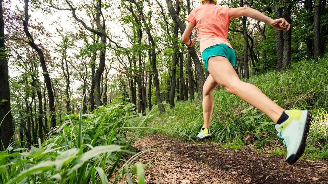 Kobieta biegnąca po lesie