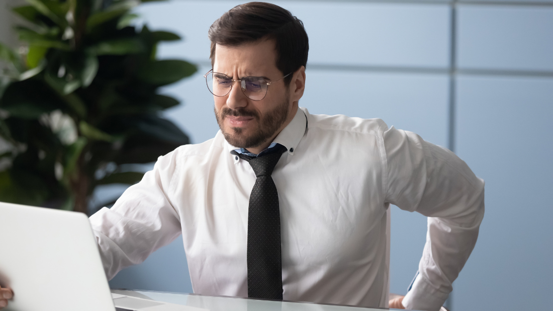 Ból kręgosłupa doskwierający mężczyźnie podczas pracy siedzącej Ból kręgosłupa doskwierający mężczyźnie podczas pracy siedzącej