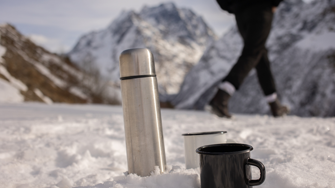 Termos z kubkami na tle gór Termos z kubkami na tle gór